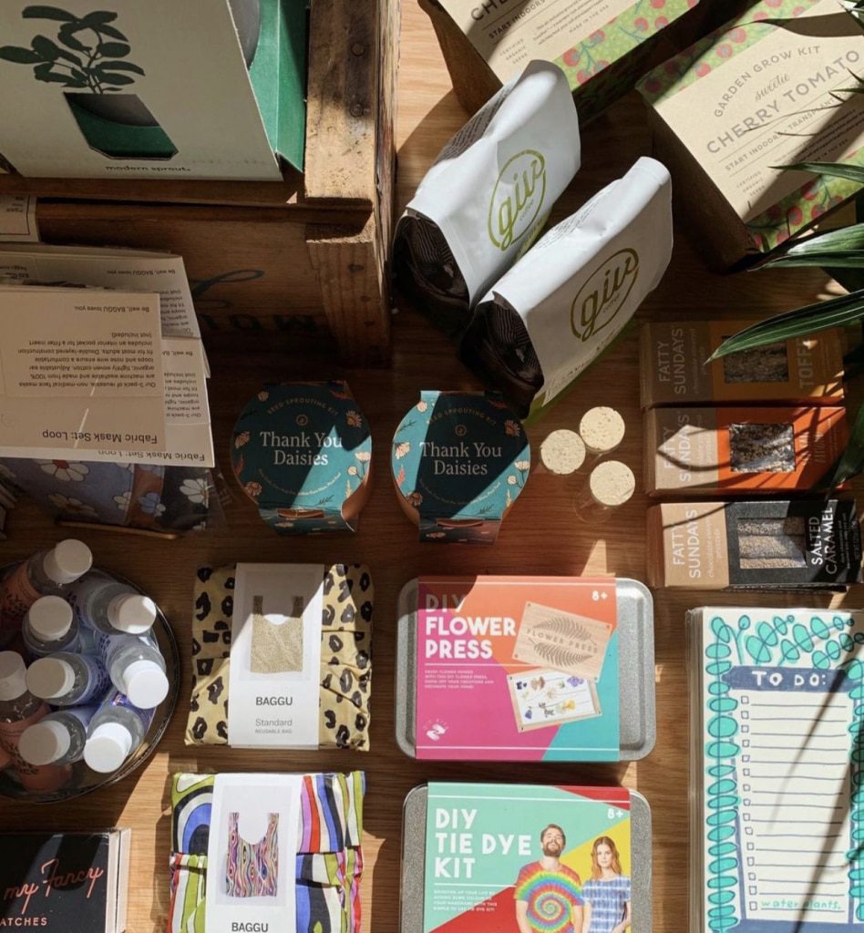 Overhead shot of a table full of items from Hartford Print!'s spring collection including reusable bags, DIY kit and local snacks & coffee.