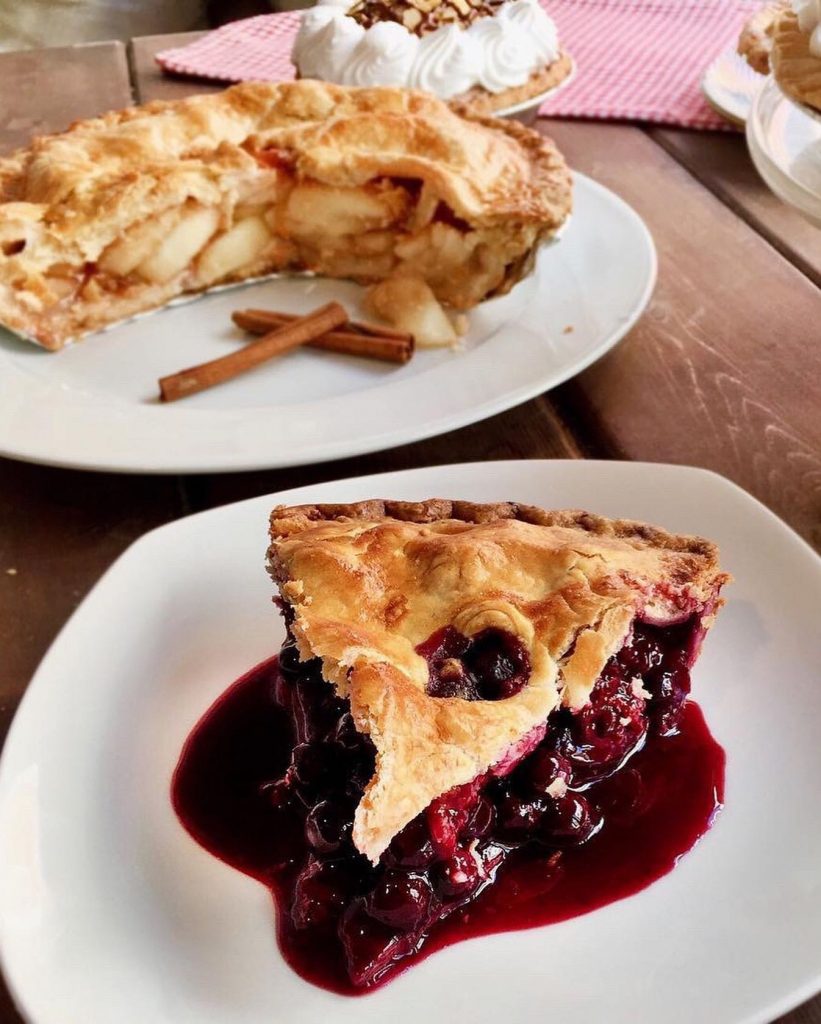 A slice of berry pie with a slice of pie in the background.
