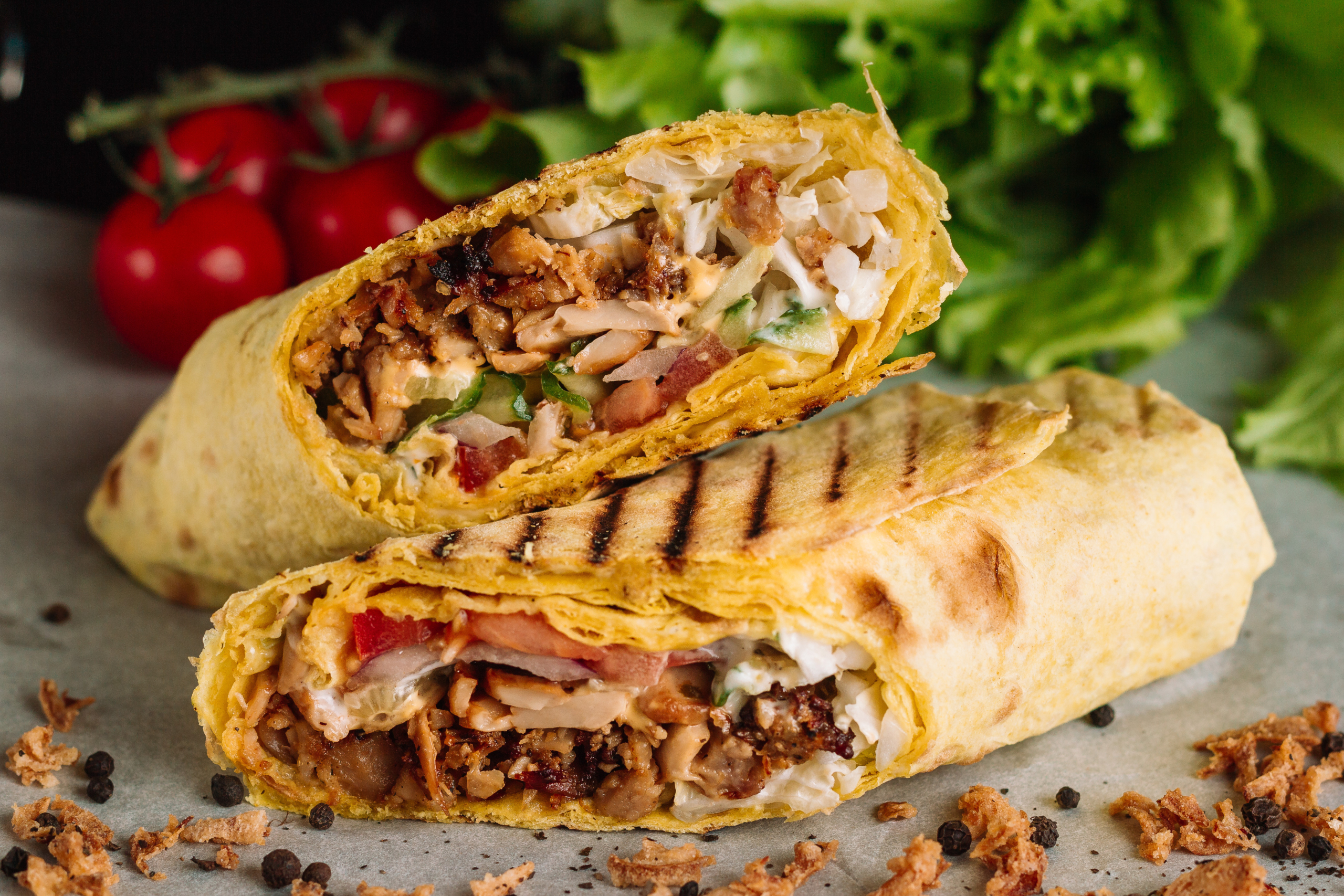 Shawarma sandwich gyro fresh roll of lavash pita bread chicken beef shawarma falafel RecipeTin Eatsfilled with grilled meat, mushrooms, cheese. Traditional Middle Eastern snack. On wooden background.