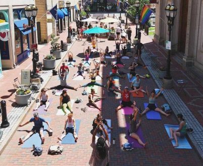 Aerial shot of people doing yoga outdoors on Pratt Street