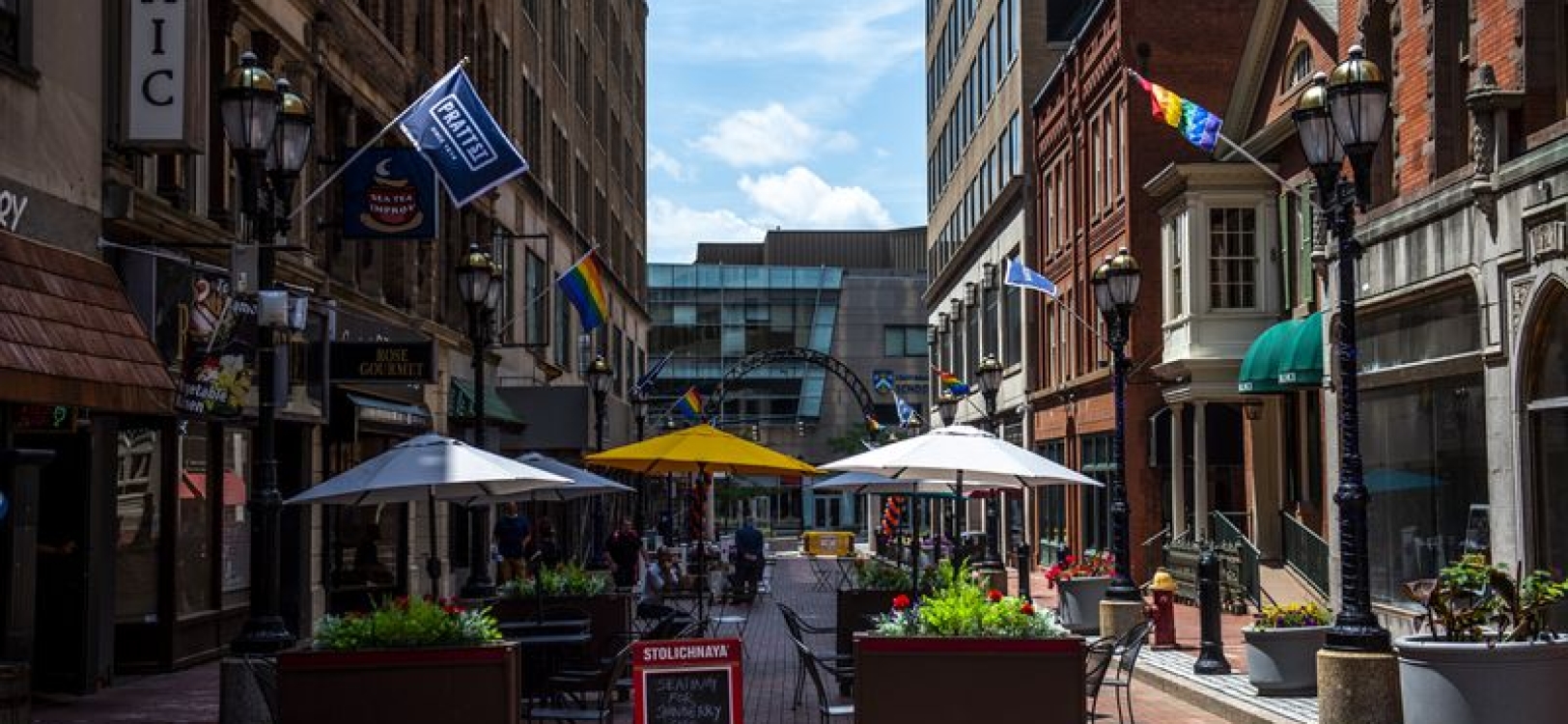 Sunny day on Pratt Street Patio with tables and chairs set up from restaurants.